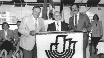 Au tournant des années 1990, M. Daoust, à droite, pose en compagnie de M. Roger Dionne, alors président du CA de l'OMHM et de M. Grégoire, président de l'association de locataires des habitations Rousselot, lors de la remise de cette oeuvre reproduisant le 1er logo de l'OMHM.